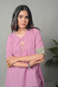 Woman wearing a pink kurta with a gray background