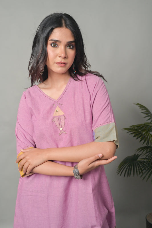 Woman wearing a pink kurta with a gray background