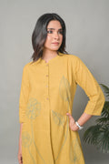 Woman wearing a yellow kurta with floral embroidery against a gray background