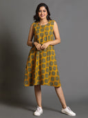 A woman posing in a mustard yellow Ajrakh block-printed dress with Kantha hand embroidery detailing, featuring a flared hem and three-quarter sleeves.